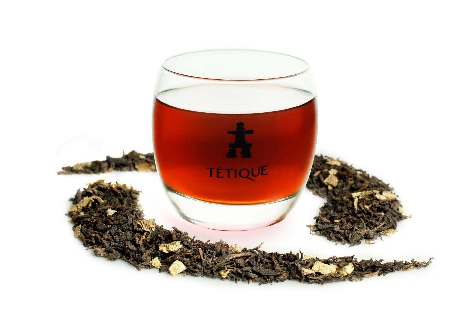 Té Negro Canela ecológico a granel en vaso con ramas de canela y hojas de té alrededor.